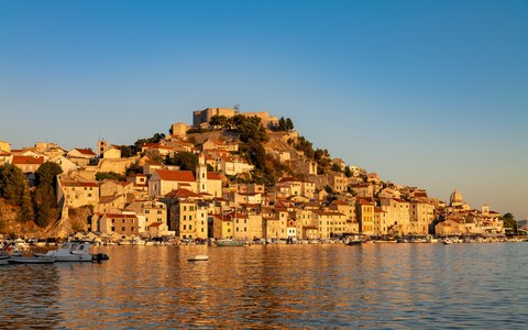 Blick auf die alten Steinhäuser, die sich in Šibenik über dem Wasser einen Hügel hinauf aneinanderreihen