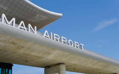 Geschwungenes Terminalvordach mit großem Airport-Schriftzug am Flughafen Franjo Tuđman Zagreb