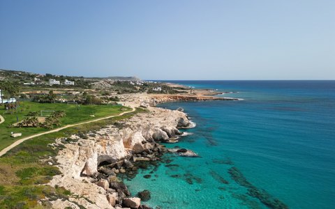Helle Felsklippen am Meer mit einem Fußweg entlang der Oberkante, aus der Luft gesehen