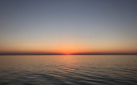 Sonnenuntergang über dem ruhigen Schwarzen Meer bei Kobuleti unter klarem Abendhimmel