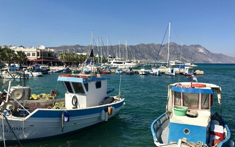 Fischerboote und Jachten im Hafen von Kardamaina auf Kos, dahinter Berge