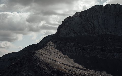 Die zerklüfteten dunklen Hänge des Olymp unter einem dramatischen Wolkenhimmel