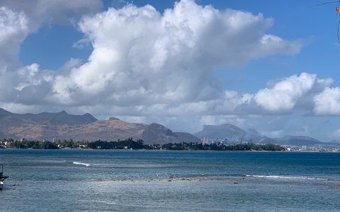 Das Meer bei Port Louis mit der Stadt und ihren Bergen dahinter