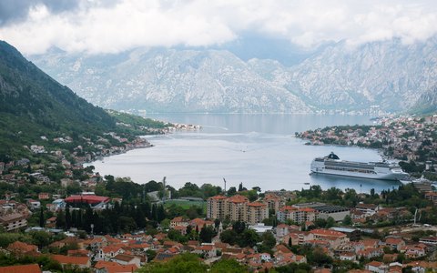 Die Dächer von Kotor unter steilen grauen Bergen, mit der Bucht