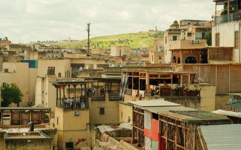 Flache Dächer und alte Gebäude der Medina von Fès unter blauem Himmel mit weißen Wolken