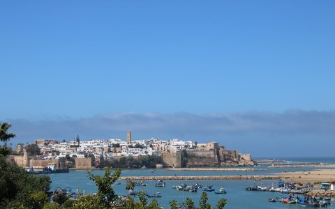 Blick auf die ummauerte Altstadt und die weißen Häuser von Rabat über der Flussmündung und dem blauen Meer