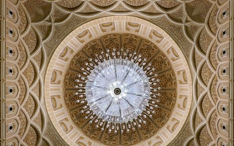 Die verzierte Kuppel und der große Kronleuchter im Inneren der Sultan-Qabus-Moschee in Salalah