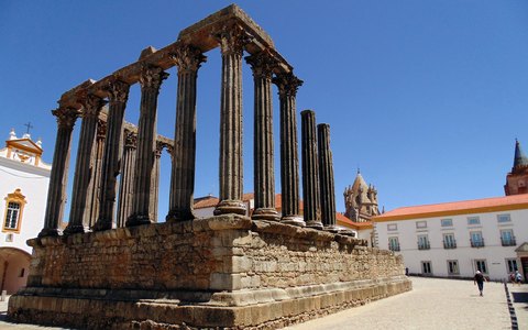 Die Granitsäulen des römischen Tempels in Évora vor leuchtend blauem Himmel