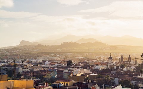 Dächer und Kirchtürme von La Laguna vor Bergen im warmen Morgenlicht