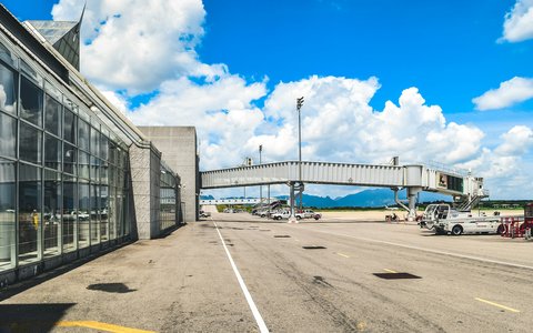 Gläsernes Terminalgebäude und Fluggastbrücke auf dem Vorfeld des Flughafens Krabi