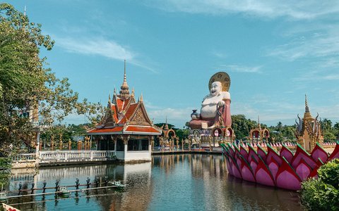 Tempelpavillon, lotusförmiges Boot und eine große Statue des Lachenden Buddha am See von Wat Plai Laem auf Koh Samui