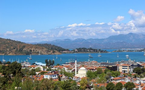 Luftbild von Fethiye, Hafen und Bucht mit Bergen im Hintergrund unter blauem Himmel mit weißen Wolken