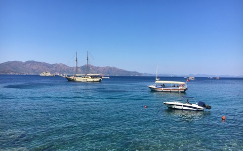 Boote auf dem ruhigen blauen Wasser der Bucht von Marmaris mit Hügeln im Hintergrund unter klarem blauem Himmel