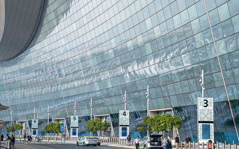 Gläserne Terminalfront und Vorfahrtspuren am Flughafen Abu Dhabi