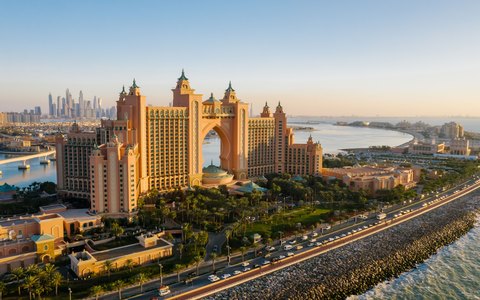 Luftbild des Hotels Atlantis The Palm bei Sonnenuntergang mit der Straße auf Palm Jumeirah und dem Meer